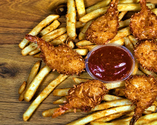 Breaded jumbo shrimp on fries around a cup of cocktail sauce